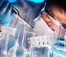 scientist pipeting a liquid into a test tube